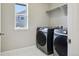 Well-lit laundry room featuring a washer and dryer set, and a window to the neighborhood at 6558 Kenzie Cir, Castle Pines, CO 80108