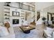 Stylish open-concept space with a fireplace, staircase, and an adjacent dining area for seamless entertaining at 6558 Kenzie Cir, Castle Pines, CO 80108