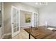 Bright office featuring a large desk, modern light fixture, and French doors to another room at 6558 Kenzie Cir, Castle Pines, CO 80108
