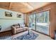 Cozy living room showcasing wood ceiling, a leather couch, and scenic views through large glass doors at 5739 Highway 9, Breckenridge, CO 80424