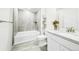 Full bathroom featuring a soaking tub, a shower, and gray tile at 8867 S Zante St, Aurora, CO 80016