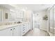 Bright bathroom with dual sinks, white cabinets, granite countertops, and tiled floors and shower at 8867 S Zante St, Aurora, CO 80016