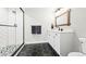 Modern bathroom with white subway tile shower and black-and-white hexagon tile flooring at 8867 S Zante St, Aurora, CO 80016