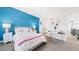 Bright bedroom with blue accent wall, plush carpet, and an attached bathroom and study area at 8867 S Zante St, Aurora, CO 80016