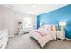 Charming bedroom featuring bright blue accent wall, cozy carpet, and ample natural light at 8867 S Zante St, Aurora, CO 80016