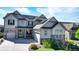 Attractive, light grey two-story home with stone accents, solar panels, three-car garage and professional landscaping at 8867 S Zante St, Aurora, CO 80016