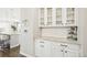 Additional kitchen storage includes white cabinets, granite countertops, and glass front display cabinets at 8867 S Zante St, Aurora, CO 80016