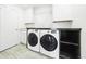 Bright laundry room featuring modern Samsung washer and dryer, complemented by ample cabinet and shelf space at 8867 S Zante St, Aurora, CO 80016