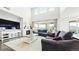 Bright living room featuring large windows, a fireplace, neutral tones and cozy furniture at 8867 S Zante St, Aurora, CO 80016