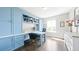 Home office with custom blue built-ins, desk, and hardwood flooring at 8867 S Zante St, Aurora, CO 80016