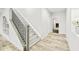 Elegant staircase with sleek black railing, flowing into stylish hallway with white trim and light-toned wood flooring at 8867 S Zante St, Aurora, CO 80016