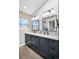 Bathroom with dual sinks, modern lighting, quartz countertops, and wood-look flooring at 1621 Beacon Hill Dr, Highlands Ranch, CO 80126