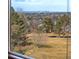 Breathtaking city view of downtown Denver framed by a window and lush green landscape at 1621 Beacon Hill Dr, Highlands Ranch, CO 80126