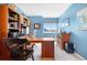 Bright home office with classic wooden furniture, blue walls, and a large window at 1621 Beacon Hill Dr, Highlands Ranch, CO 80126