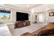 Bright living room with a large TV, a comfortable seating area, and natural light streaming through the windows at 1621 Beacon Hill Dr, Highlands Ranch, CO 80126