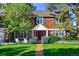 Stunning two-story home with stone pathway, lush lawn, and mature trees at 7205 S Newport Way, Centennial, CO 80112