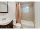 Updated bathroom features a new vanity, toilet, and a shower-tub combination with a tan shower curtain at 1707 W 39Th Ave, Denver, CO 80211