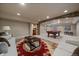 Basement with brick features, plush sofas, dark coffee table and pool table in next room at 15258 W 75Th Pl, Arvada, CO 80007