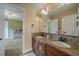 Bathroom with granite counters, dual sinks, mosaic backsplash and walk in door to the bedroom at 15258 W 75Th Pl, Arvada, CO 80007