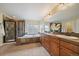Bathroom featuring double sinks, a soaking tub, and a separate glass-enclosed shower at 15258 W 75Th Pl, Arvada, CO 80007