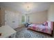 Cozy bedroom features a plush rug, neutral walls, and a charming chandelier above at 15258 W 75Th Pl, Arvada, CO 80007