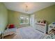 Bright bedroom features a neutral carpet, light green paint, and a decorative area rug at 15258 W 75Th Pl, Arvada, CO 80007