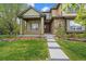 Charming home featuring a covered porch, stone accents, and a well-manicured lawn at 15258 W 75Th Pl, Arvada, CO 80007