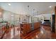 Bright kitchen with a large island, stainless steel appliances, and hardwood floors, seamlessly connecting to the dining area at 15258 W 75Th Pl, Arvada, CO 80007