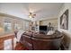 Bright living room with a stone fireplace, hardwood floors, and large windows offering ample natural light at 15258 W 75Th Pl, Arvada, CO 80007