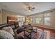 Inviting living room featuring a leather sectional, ceiling fan, hardwood floors, and a seamless transition to the kitchen at 15258 W 75Th Pl, Arvada, CO 80007