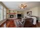 Cozy living room features a stone fireplace, hardwood floors, and a comfortable leather sectional at 15258 W 75Th Pl, Arvada, CO 80007