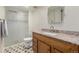 Well-lit bathroom with a shower, sink, and patterned floors at 7250 Eastmoor Dr # 105, Denver, CO 80237