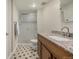 Well-lit bathroom with a shower, sink, and patterned floors at 7250 Eastmoor Dr # 105, Denver, CO 80237