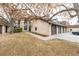 Exterior of home displaying two-car garage, brick facade, and mature trees in a manicured lawn at 7250 Eastmoor Dr # 105, Denver, CO 80237