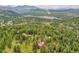 An aerial view shows the property's location amongst lush greenery, towering trees, and a body of water at 28065 Camel Heights Cir, Evergreen, CO 80439
