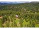 Expansive aerial view of home nestled amongst many trees in scenic mountain community at 28065 Camel Heights Cir, Evergreen, CO 80439