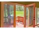 View of the deck through glass doors, including a grill and wooded backyard at 28065 Camel Heights Cir, Evergreen, CO 80439