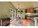 Sunlit dining area features wooden cabinets, granite counters, hardwood floors, and backyard views at 28065 Camel Heights Cir, Evergreen, CO 80439
