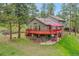 Two-story home featuring a spacious deck, set in a lush green landscape with mature trees at 28065 Camel Heights Cir, Evergreen, CO 80439