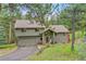 Charming home with a well-maintained lawn, an attached garage, and mature trees enhancing curb appeal at 28065 Camel Heights Cir, Evergreen, CO 80439