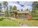 Charming two-story home features a lush lawn and manicured landscaping, with colorful flower pots lining the walkway at 28065 Camel Heights Cir, Evergreen, CO 80439