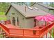 View of the house exterior with a large deck, seating, and a red umbrella at 28065 Camel Heights Cir, Evergreen, CO 80439