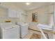 Bright laundry room equipped with a washer, dryer, sink, and ample storage for convenience at 28065 Camel Heights Cir, Evergreen, CO 80439