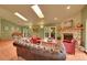 Spacious living room with a piano, stone fireplace, and plenty of natural light from multiple windows at 28065 Camel Heights Cir, Evergreen, CO 80439