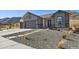 View of the house with gray siding, stone accents and a xeriscaped front yard at 4526 Mesa Top Dr, Monument, CO 80132