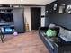 Living room with modern black shelving unit, complemented by hardwood floors and a comfortable leather couch, great for relaxation at 7486 Patrick St, Fort Lupton, CO 80621