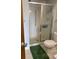 Bathroom with tiled shower and commode and a green floor mat at 9335 E Center Ave # 7C, Denver, CO 80247