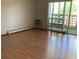 Bright living room with hardwood floors, a sliding glass door, and an air conditioner at 9335 E Center Ave # 7C, Denver, CO 80247