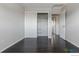 Empty bedroom showing sliding closet doors and a neutral color palette with dark hardwood floors at 10560 W 102Nd Pl, Broomfield, CO 80021