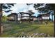 Modern home featuring large windows, balconies, and a beautifully landscaped lawn at 7935 Dante Dr, Littleton, CO 80125